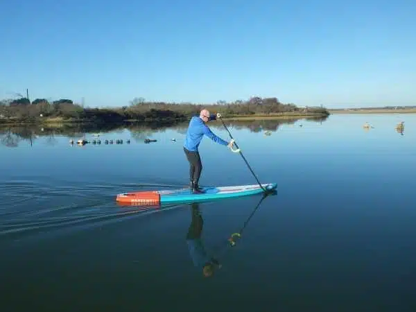 Un homme sur une planche à pagaie dans un lac