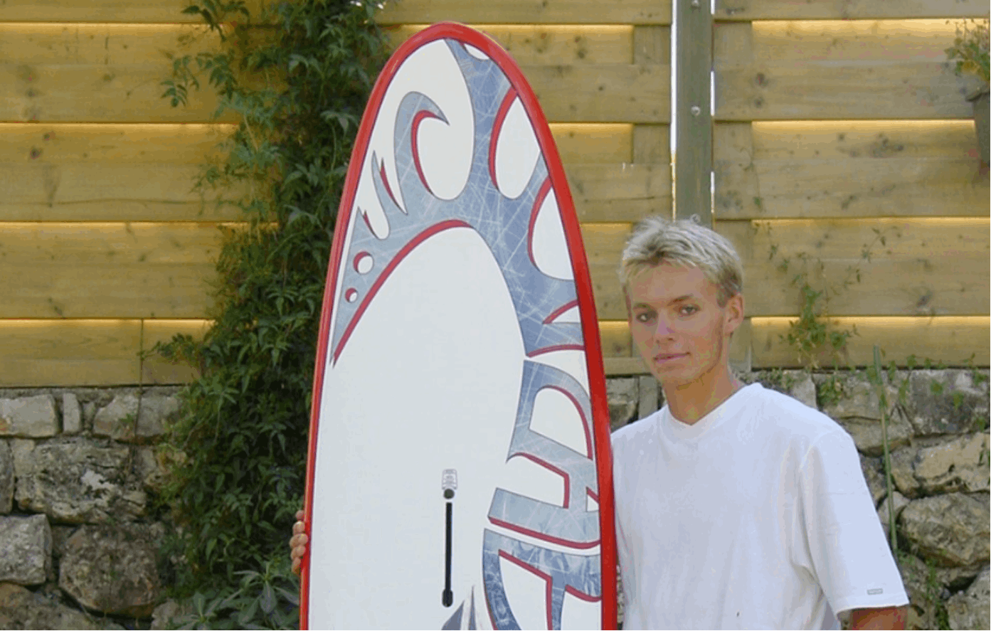 Un homme tenant une planche de surf