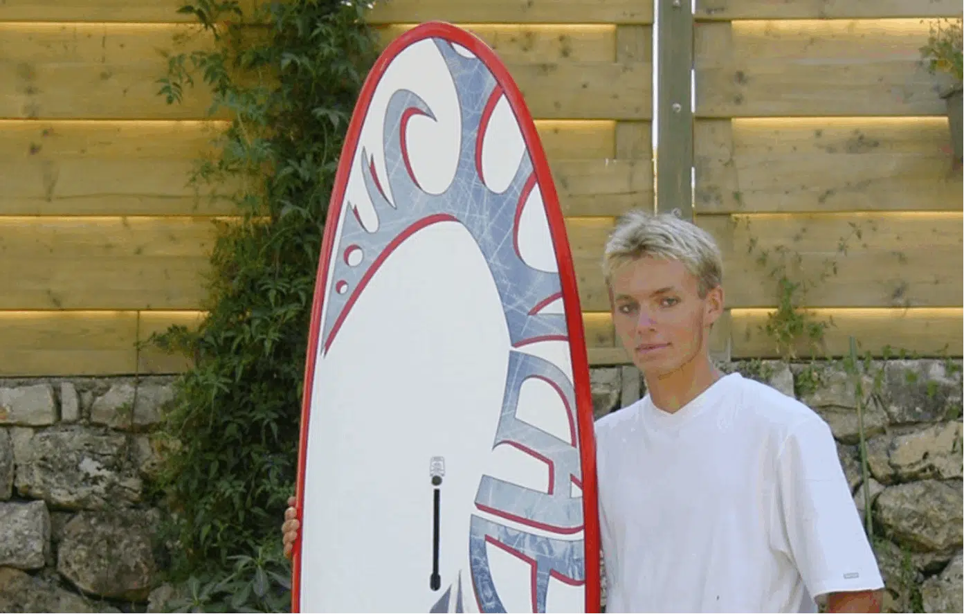 Un homme tenant une planche de surf